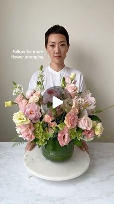 a man sitting in front of a flower arrangement on a table with the caption follow for more flowers arranging