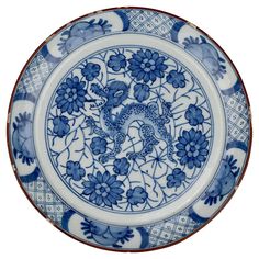 a blue and white plate with an animal design on the front, surrounded by flowers