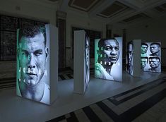 an art installation with multiple images of the same man on display in front of them