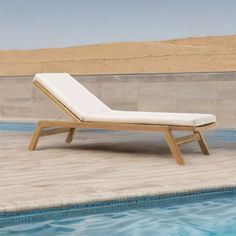 a lounge chair sitting next to a swimming pool in the middle of an empty area