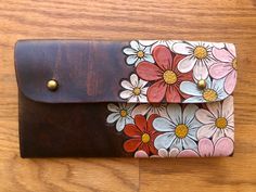 a leather wallet with flowers painted on it