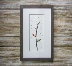 a white frame with a red bird sitting on a tree branch in the middle of it