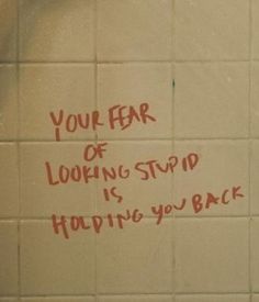 graffiti written on the side of a bathroom wall