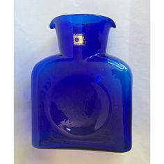 a blue glass vase sitting on top of a table