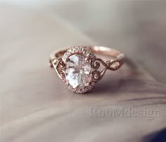 a white diamond ring sitting on top of a bed