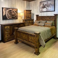 a large wooden bed sitting in a bedroom next to a painting on the wall above it