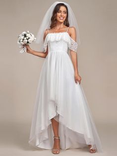 a woman in a white wedding dress holding a bridal bouquet and posing for the camera