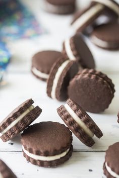 chocolate cookies with white frosting are arranged on a table