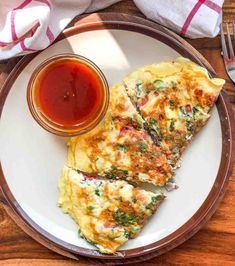 two omelets on a plate with ketchup