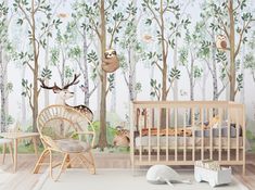 a baby's room with trees and animals on the wall, including a crib