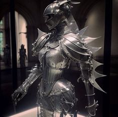 a knight in armor standing on display at a museum