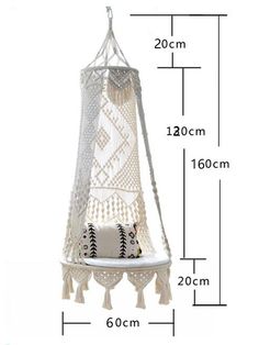 a white hanging hammock with fringes and tassels on the bottom