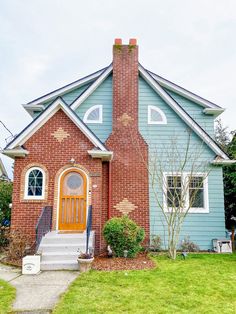 a blue and red brick house with white trim