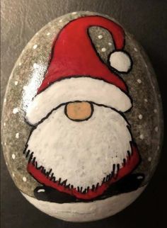 a painted rock with a santa clause on it