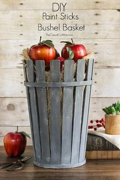 an old bucket filled with apples sitting on top of a table