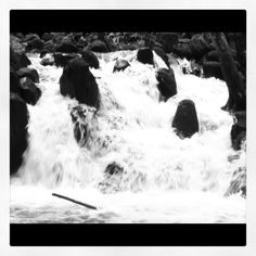 black and white photograph of water rushing over rocks