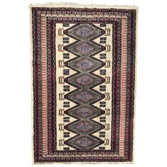 an antique afghan rug with multicolored patterns and fringes