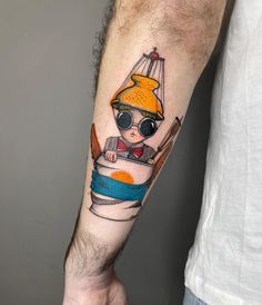 a man's arm with a cartoon character on it, and an orange hat