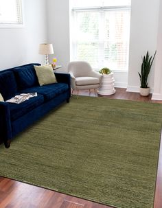 a living room with a blue couch and green rug