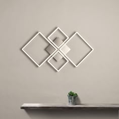 a white shelf with a potted plant sitting on top of it next to a wall mounted mirror