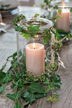 a table with candles and greenery on it