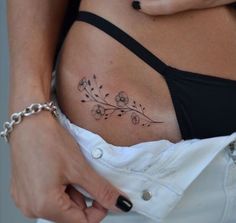 a woman's stomach with a tattoo on her belly and flowers in the middle