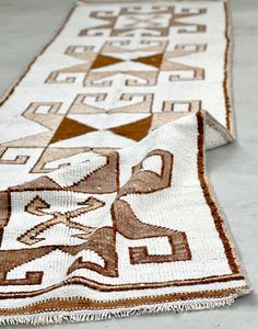 two brown and white rugs sitting on top of each other