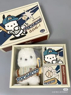 a hello kitty baseball plush toy in a box with the lid open to show it's packaging