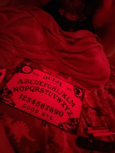 a bed covered in red sheets with a sign on the pillow that says oupa