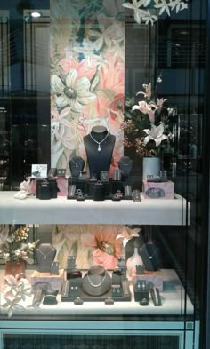 a display case filled with jewelry and flowers