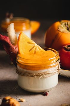 a glass jar filled with fruit sitting on top of a table next to other fruits