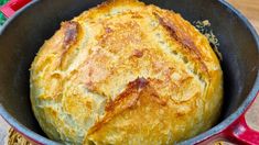 a baked bread in a red pot on a table