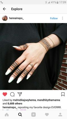 a woman's hand with henna tattoos on it