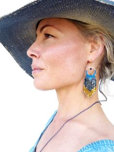 a woman wearing a large hat and earrings