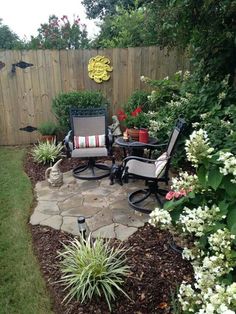 an outdoor patio area with chairs, table and flowers