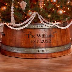 a christmas tree in a wooden barrel with ornaments around it and the name, the williams est