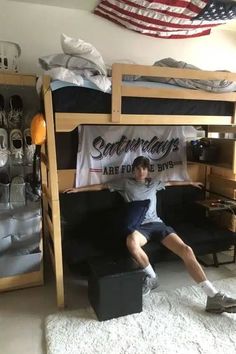 a young man sitting on top of a bunk bed in a room filled with sports memorabilia