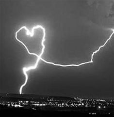 lightning striking over a city at night time