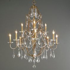 a chandelier hanging from the ceiling in a room with gray walls and flooring