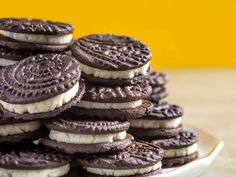 a plate full of oreo cookies with white frosting on them and stacked together