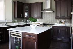 a kitchen with dark wood cabinets and white marble counter tops is pictured in this image