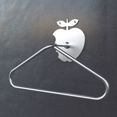 an apple shaped paper towel ring on top of a black surface with a silver handle