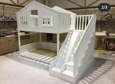 a large white bunk bed with stairs in a room that is being built into the floor