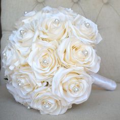 a bridal bouquet with white roses and pearls