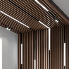 an empty room with wooden slats on the wall and lights in the ceiling above it