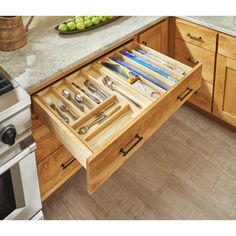 an open drawer in the middle of a kitchen