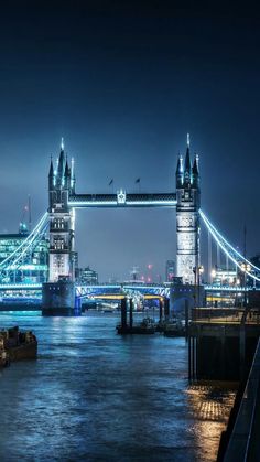 the tower bridge is lit up at night