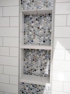 a white shelf filled with lots of different types of buttons on top of a tiled wall