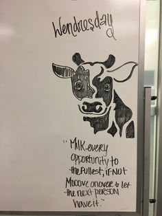 a drawing of a cow on a white board with words written in black and white