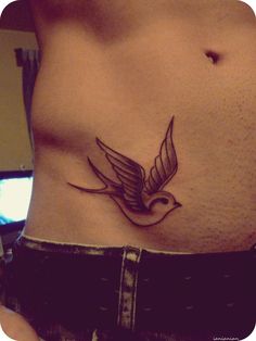 a woman's stomach with a bird tattoo on it